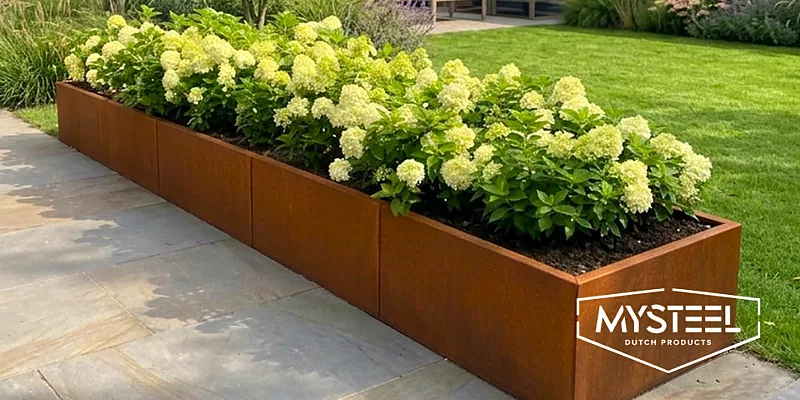 Stalen plantenbak van MySteel met hortensia’s in een tuin